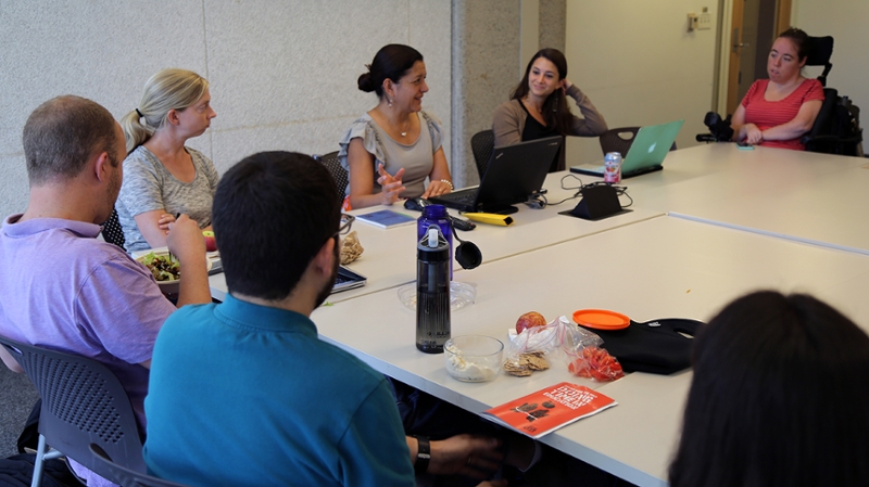PhD students and faculty conducting a meeting in a Heller conference room.