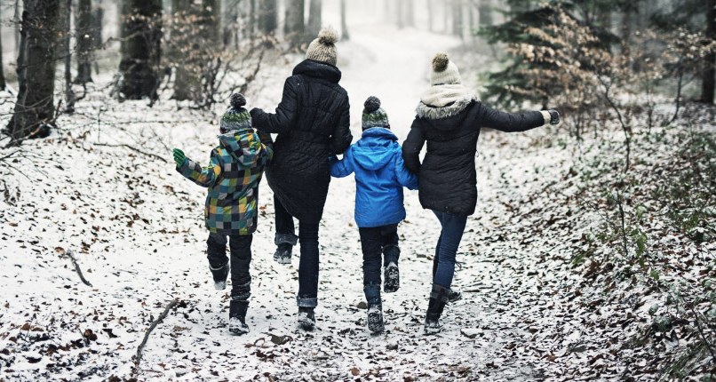 Adults and kids walking along path in snow