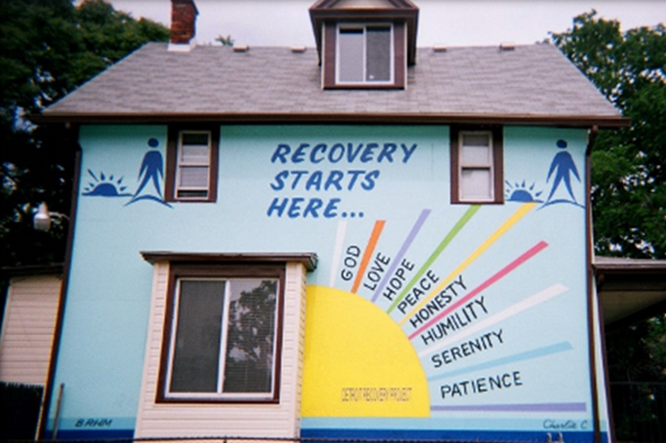 Exterior of house with sign that says "Recovery starts here"