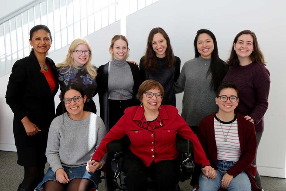 6 undergraduate Lurie fellows and Lurie director, Monika Mitra are pictured with Judy Heumann