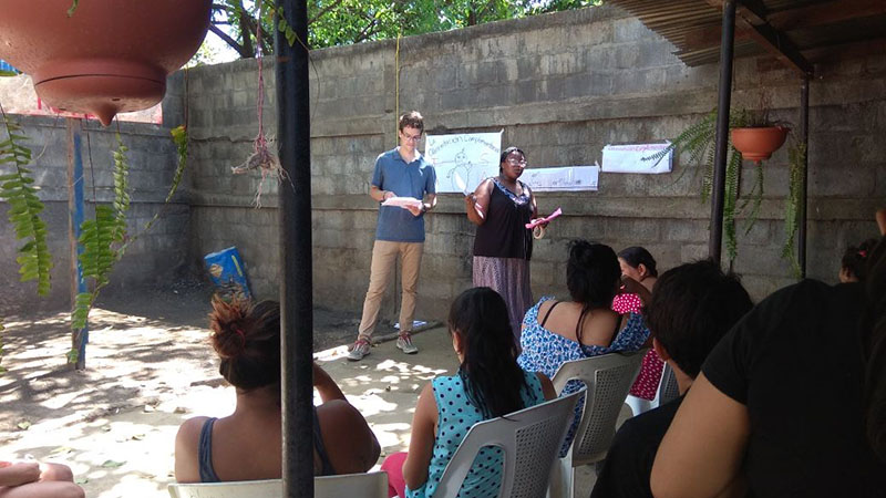 Tori Lee and a Peace Corps colleague speaking to locals in a courtyard