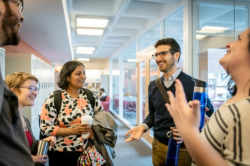 A group of students talking in a hallway of the Heller School