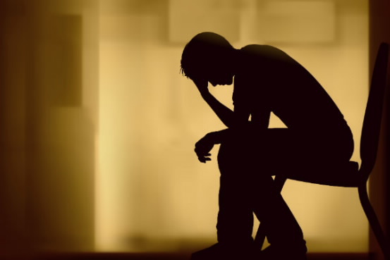 sillouette image of person with their head in their hands