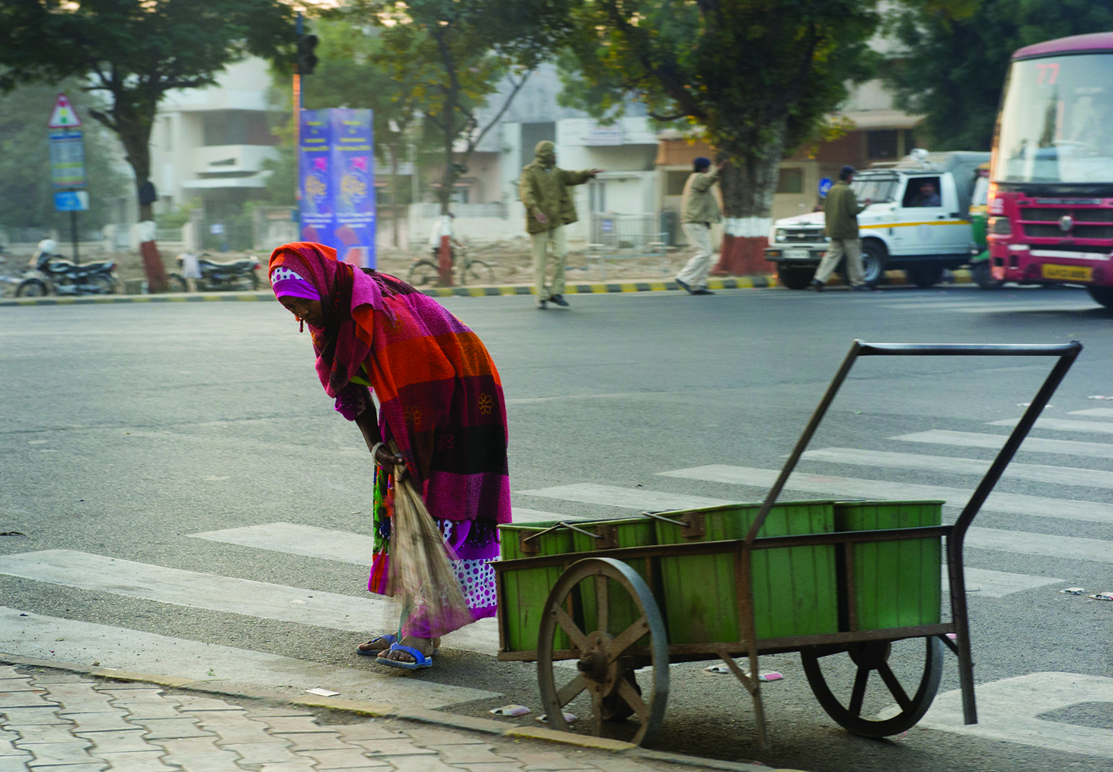 photo of woman sweeping the street in India