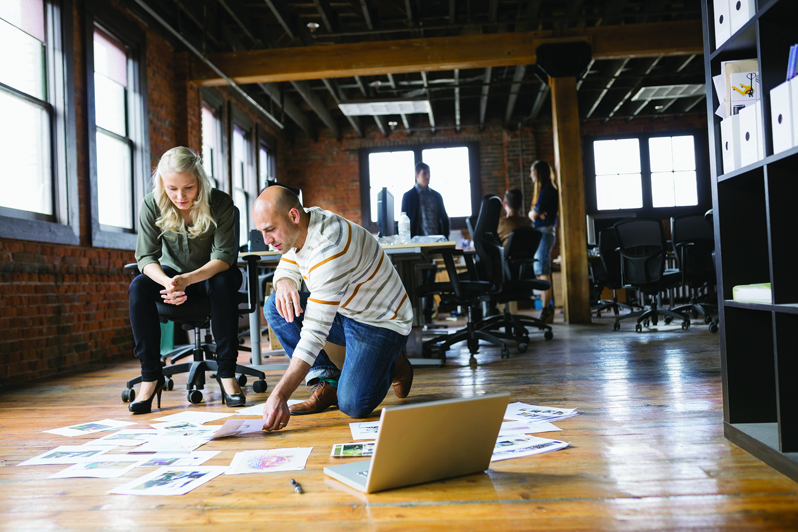 image of office workers standing around a project together