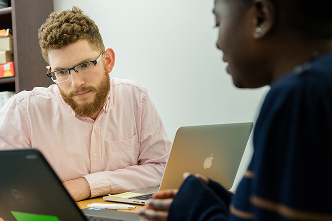 Career Development Center Associate Director Adam Motenko, MBA'16, meets with a student in his office