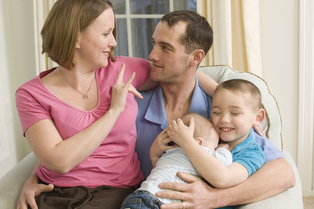 image of parents with two children speaking American Sign Language