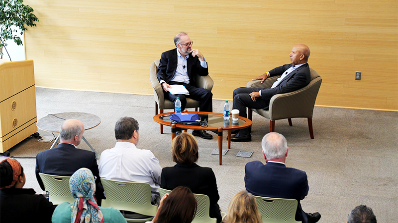 image of Dean Weil and Anthony Williams speaking in armchairs in front of a crowd in Zinner Forum
