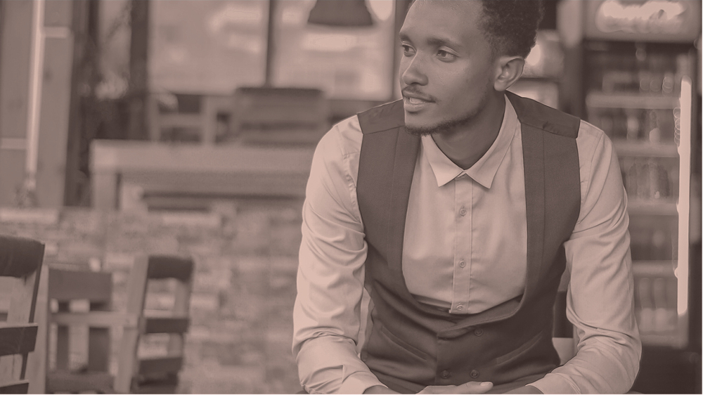 Sepia-toned photo of young Ethiopian man dressed in button-down shirt and vest