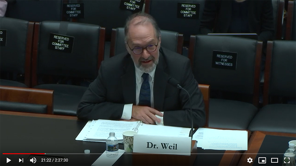 David Weil testifying with a microphone