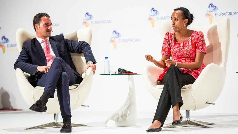 Amrote Abdella, MA SID'07, right, sitting in a white chair speaking with a man during the EurAfrica forum
