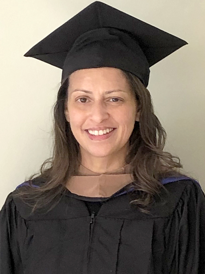 Wendy Macias-Konstantopoulos, EMBA’21, in a black commencement cap and gown