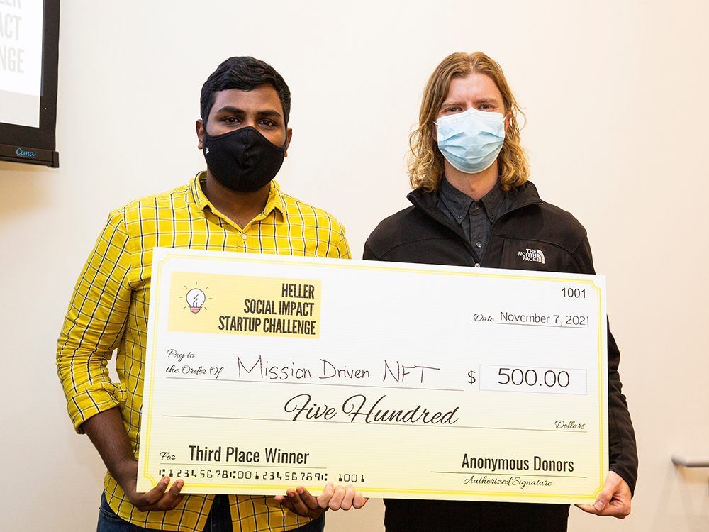 Two students pose with a check for the Mission Driven NFT team