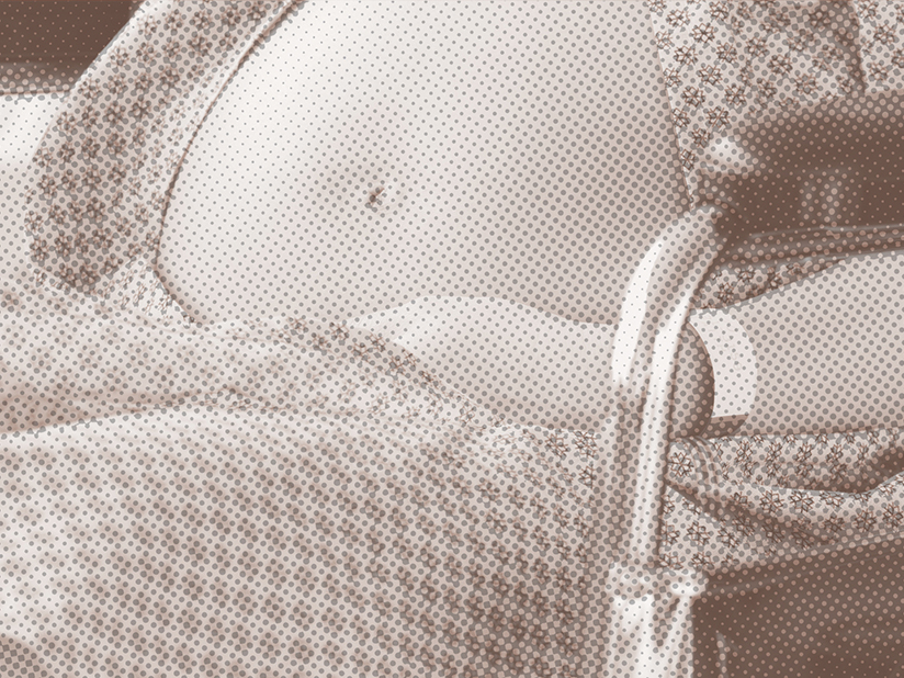 A close-up of a stomach of a pregnant person in a wheelchair, with a brown filter
