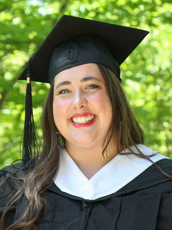 Liz Peterson, MA COEX'24, in graduation cap and gown