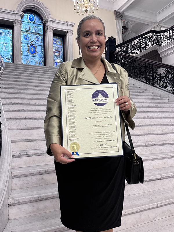 Alexandra Pineros Shields, PhD'07, inside the Massachusetts State House with her certificate of recognition from the Massachusetts Black and Latino Legislative Caucus