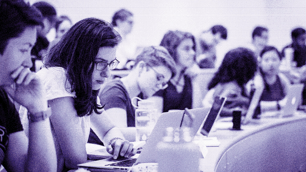A group of students taking notes during a class