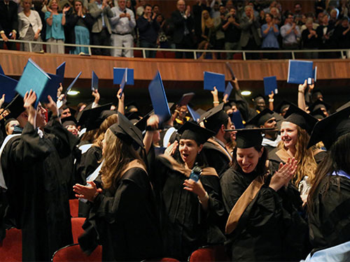 Graduates cheer at Heller's 2017 Commencement ceremony.