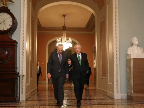 Two suited men walking and talking