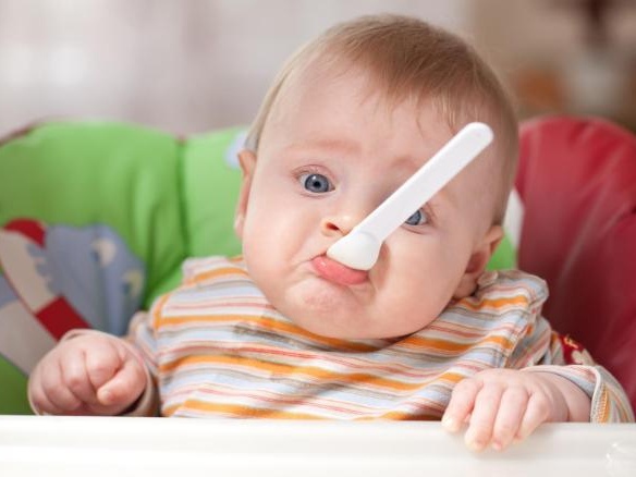 baby with spoon in its mouth