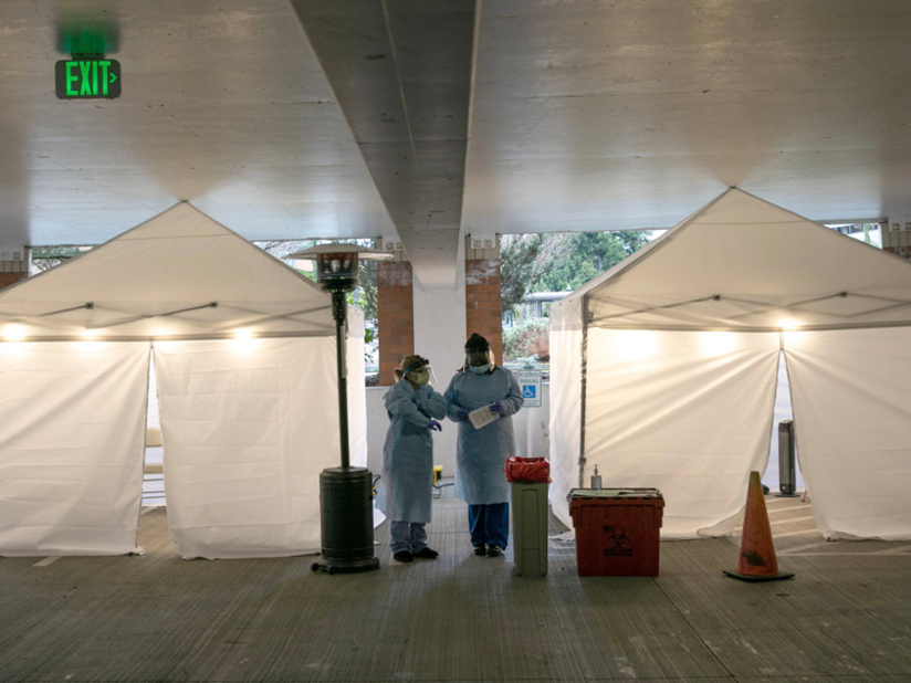 health care worker standing outside tents