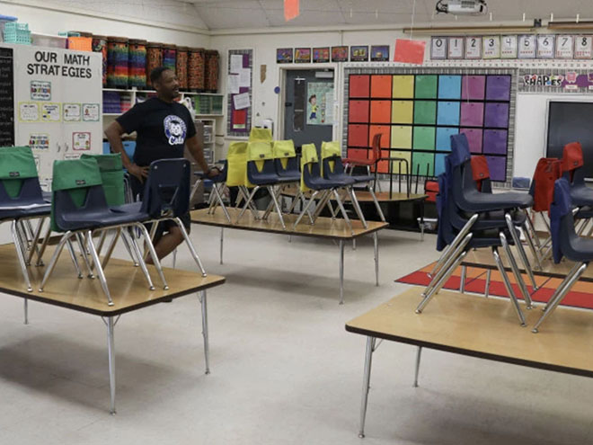 A teacher standing in a colorful classroom