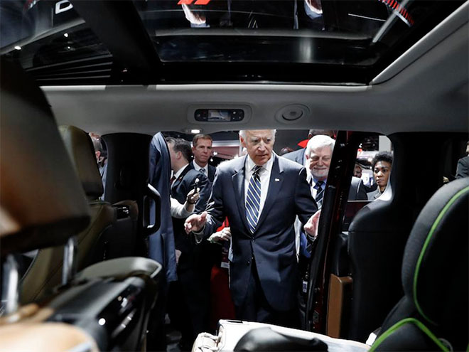 Joe Biden looking inside of a car