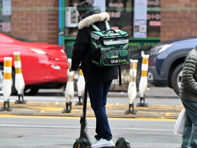An Uber Eats delivery person on a scooter