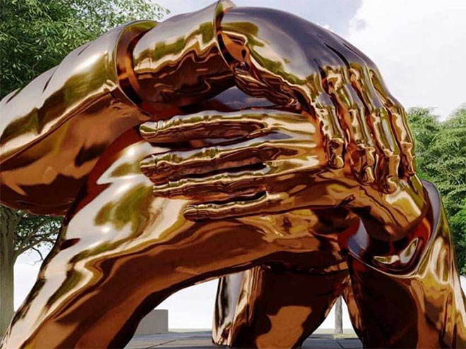 Gold sculpture of hands intertwining