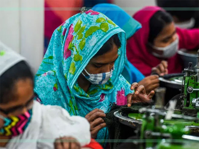 Women in headscarves and face masks working at a garment factory