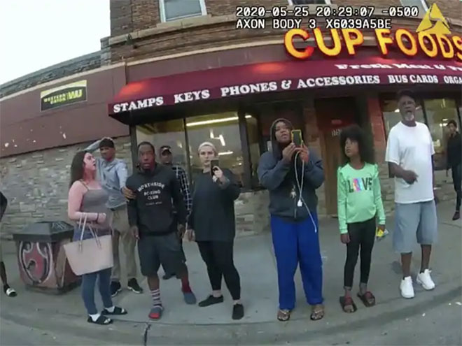 Police bodycam image of Darnella Frazier and other bystanders standing in front of Cup Foods