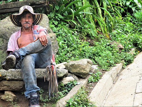 A Colombian man sits by the side of the road