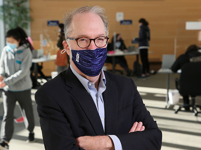 Dean David Weil in a Brandeis face mask standing in Zinner Forum