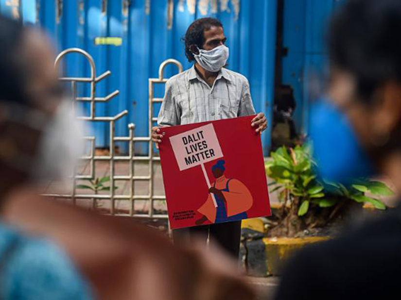 A man holds a sign that says "Dalit lives matter"