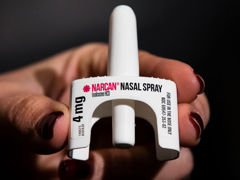 A hand holding Narcan Nasal Spray