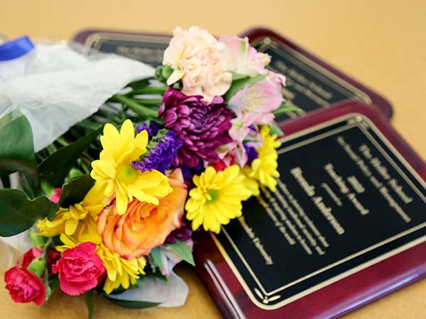 Bouquet of flowers and award plaques on a table