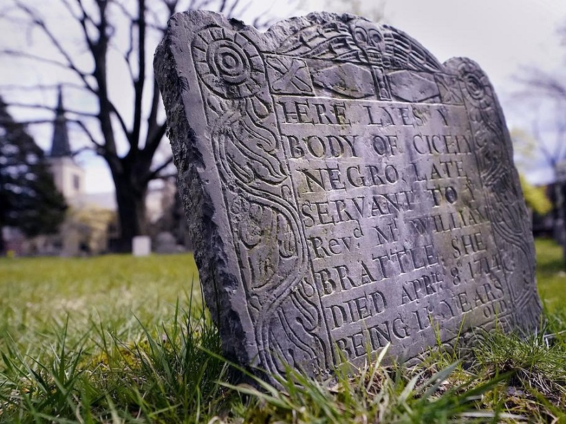 A headstone from the 18th century in a grassy field