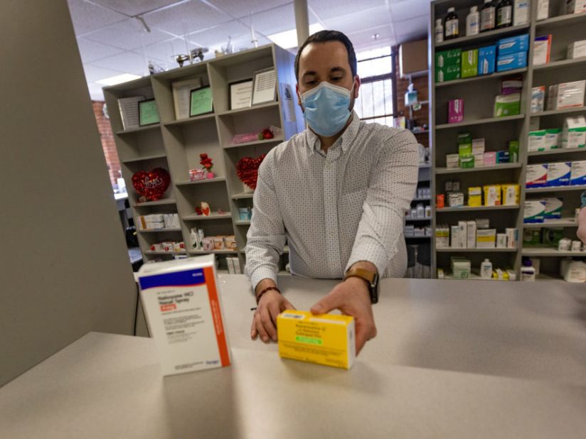 Pharmacist Andrew Terranova places a box each of Narcan and Suboxone in the window counter at Genoa Healthcare pharmacy