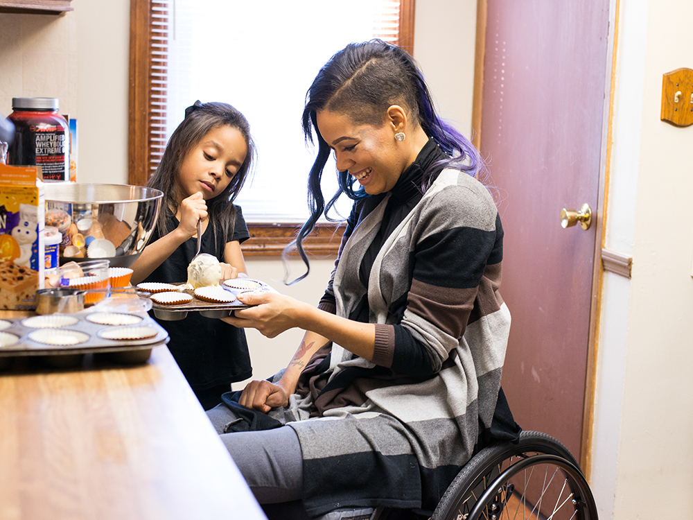 Woman in wheelchair cooks with her daughter