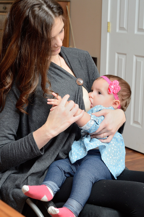 A mother using a wheelchair breastfeeding her baby