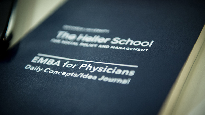 a notebook with Heller logo and EMBA for physicians logo