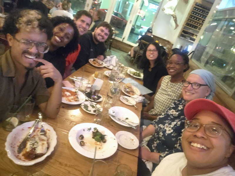 selfie of eight people around a dinner table. 
