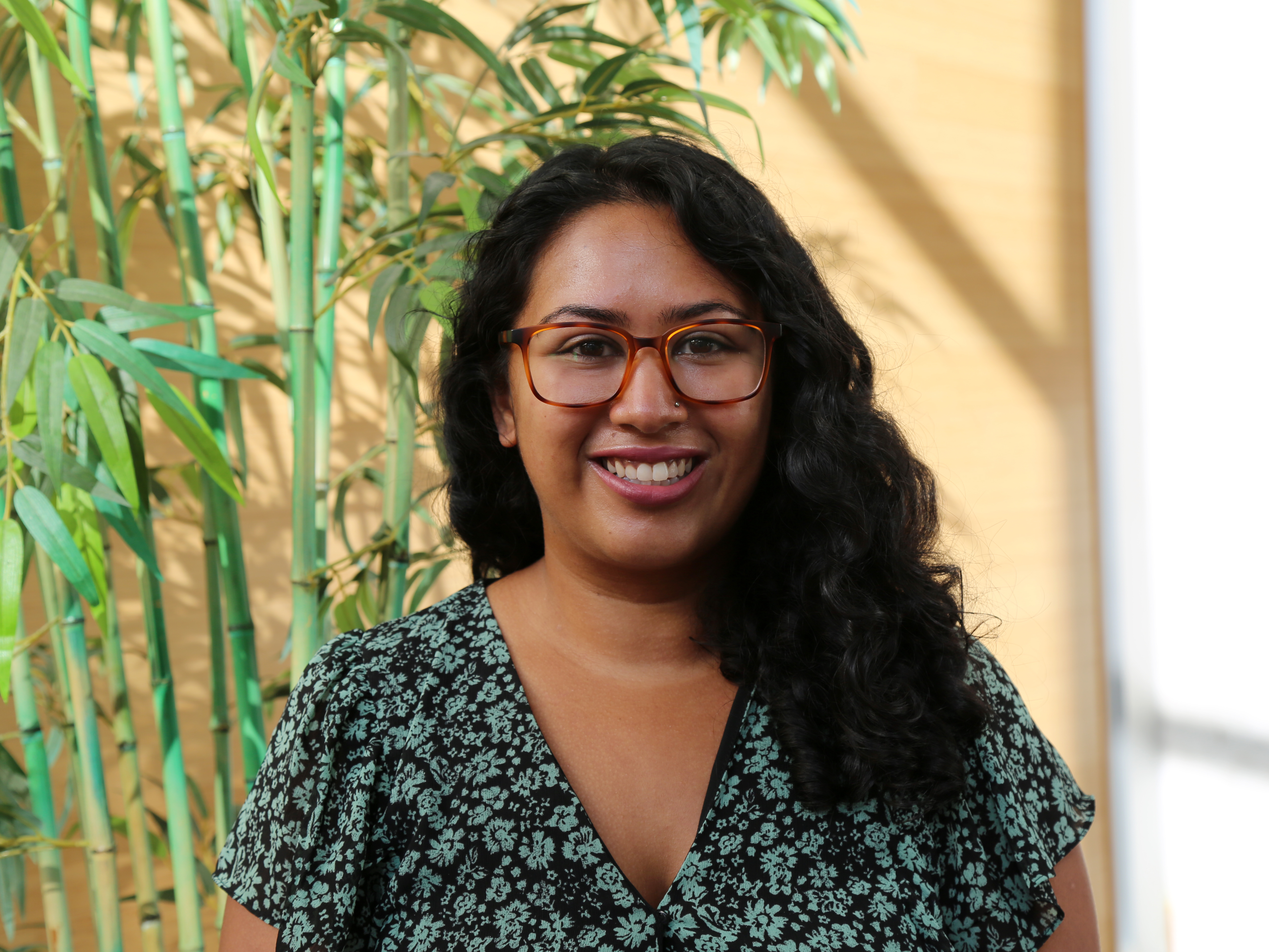 Headshot of Zora Haque smiling in a flowered shirt