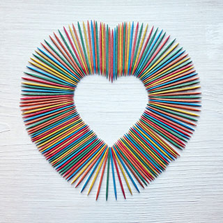 Multi-colored toothpicks arranged in a heart shape