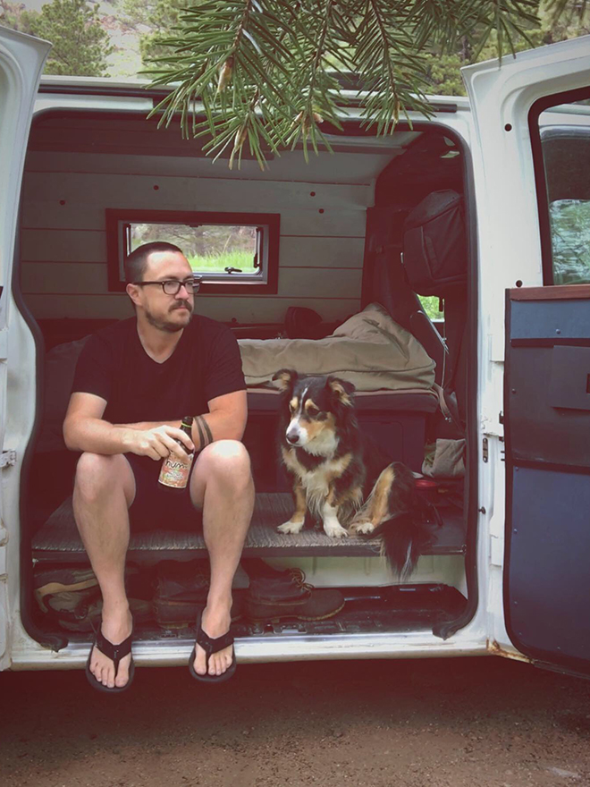 Christopher Ives, MA SID’11, holding a beer in the back of his van with his dog