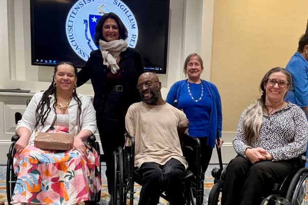 From left to right, Heather Watkins, Dr. Monika Mitra, Keith Jones, Linda Long-Bellil, and Nicole Lomerson pose together and smile for a group photo indoors.