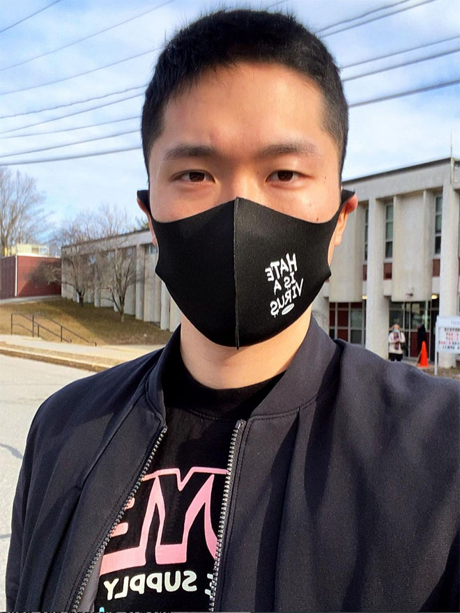 Sam Hyun, MBA/MPP'22, wearing a black face mask that says Hate is a Virus